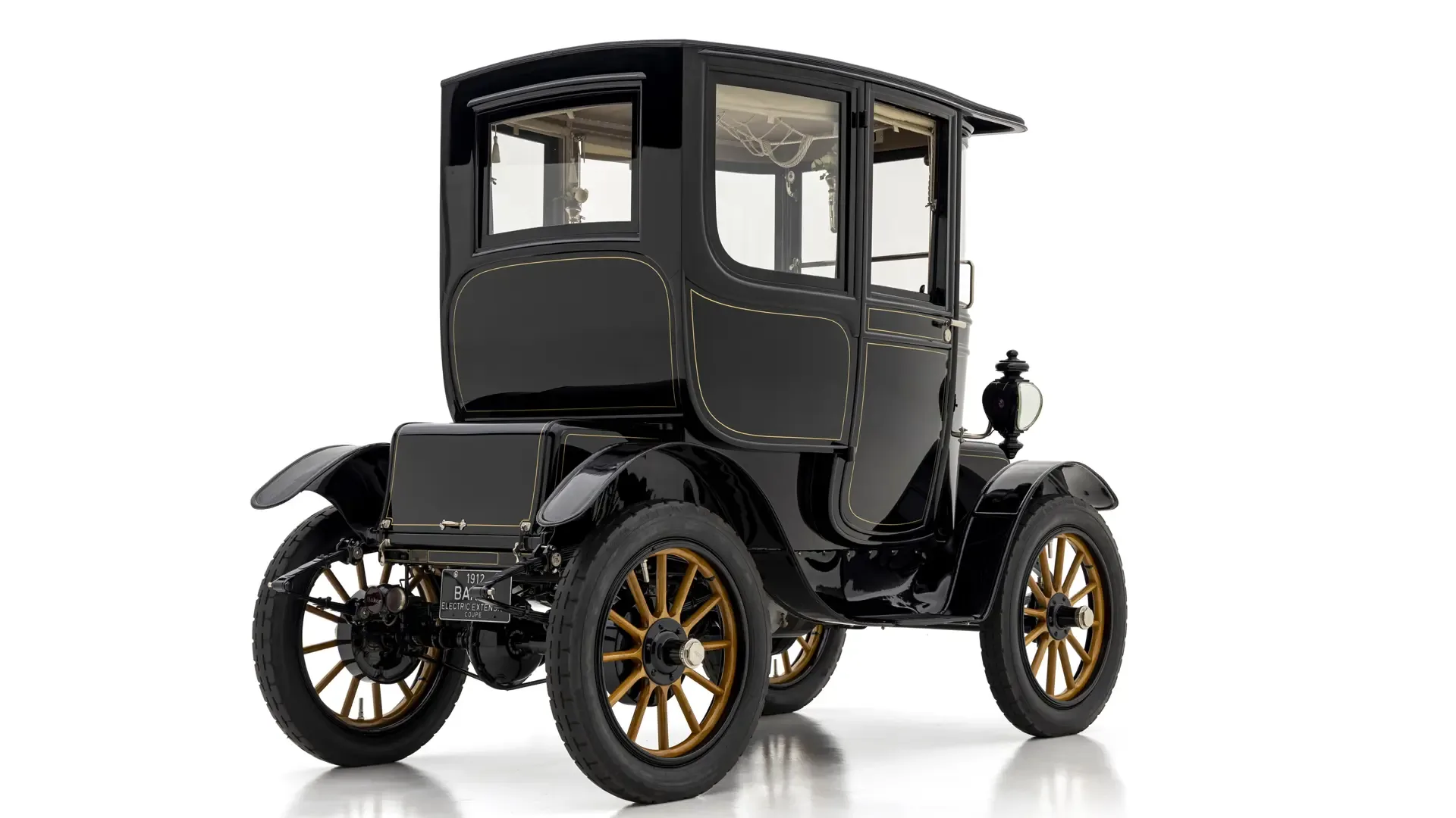Heckansicht des 1912 Baker Electric Model V Special Extension Coupe, restauriertes, schwarzes Elektroauto mit vergoldeten Speichenfelgen und luxuriösen Details.