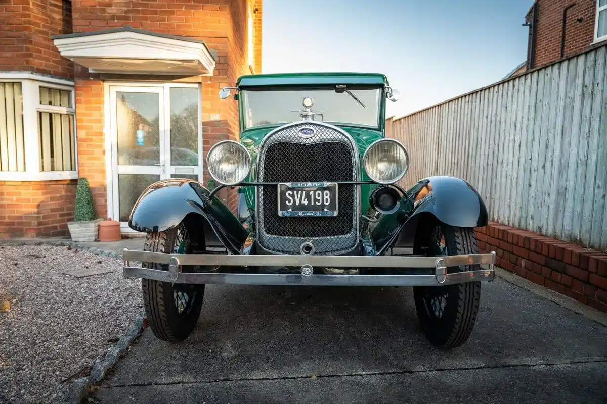 Grünes Ford Model A Baujahr 1928, Frontalansicht, vor Einfahrt eines Hauses geparkt
