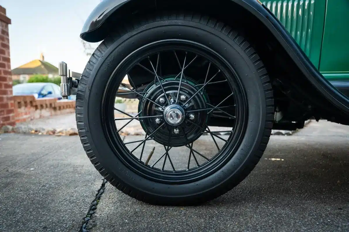 Original Speichenrad eines grünen Ford Model A von 1928 mit gut erhaltenem Reifen