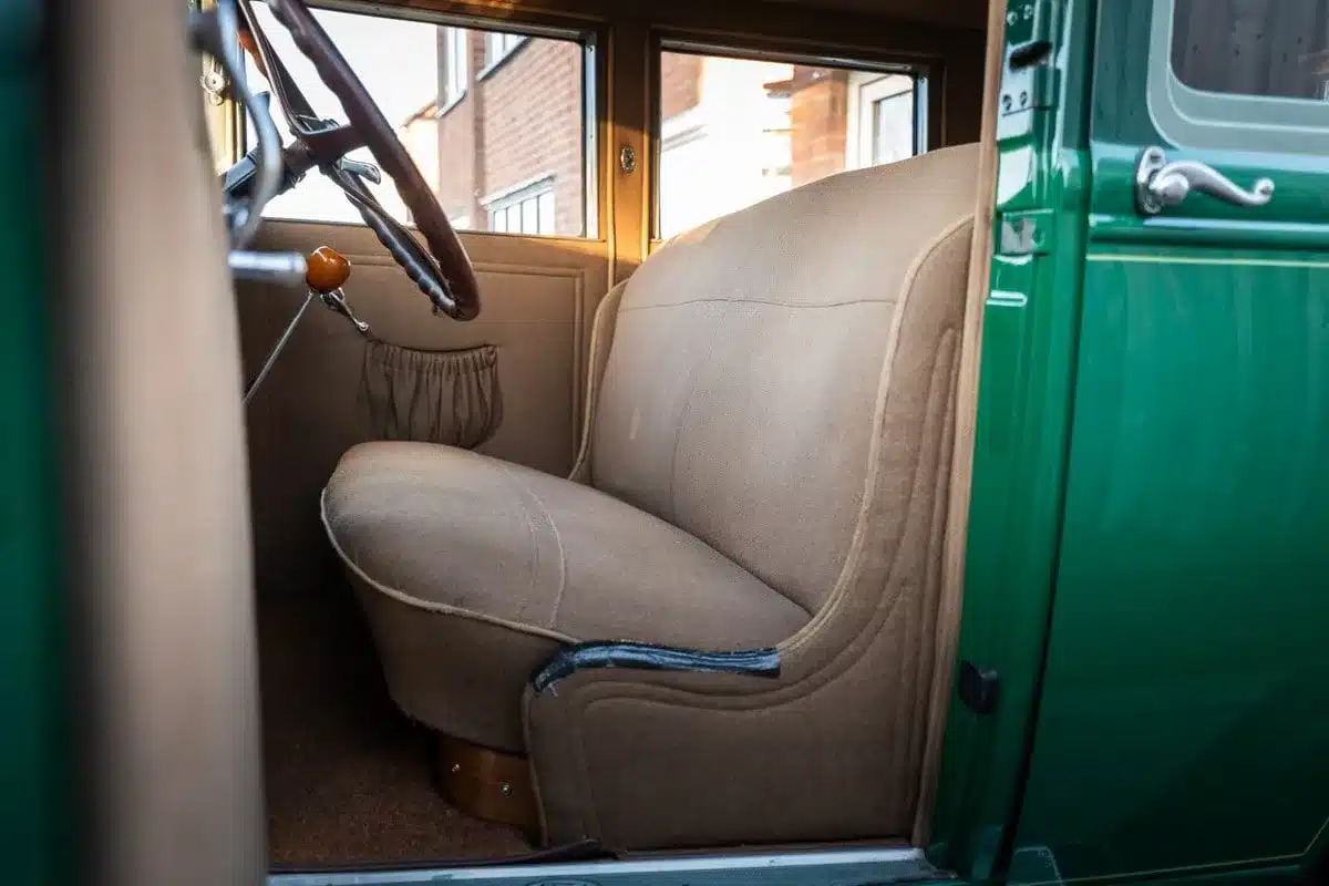 Innenansicht des Ford Model A von 1928 mit beiger Polsterbank, Lenkrad und Türverkleidung in sehr gutem Zustand.
