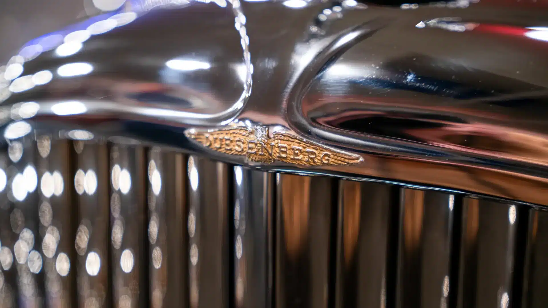 Nahaufnahme des Duesenberg-Kühlergrills mit dem goldfarbenen Markenemblem