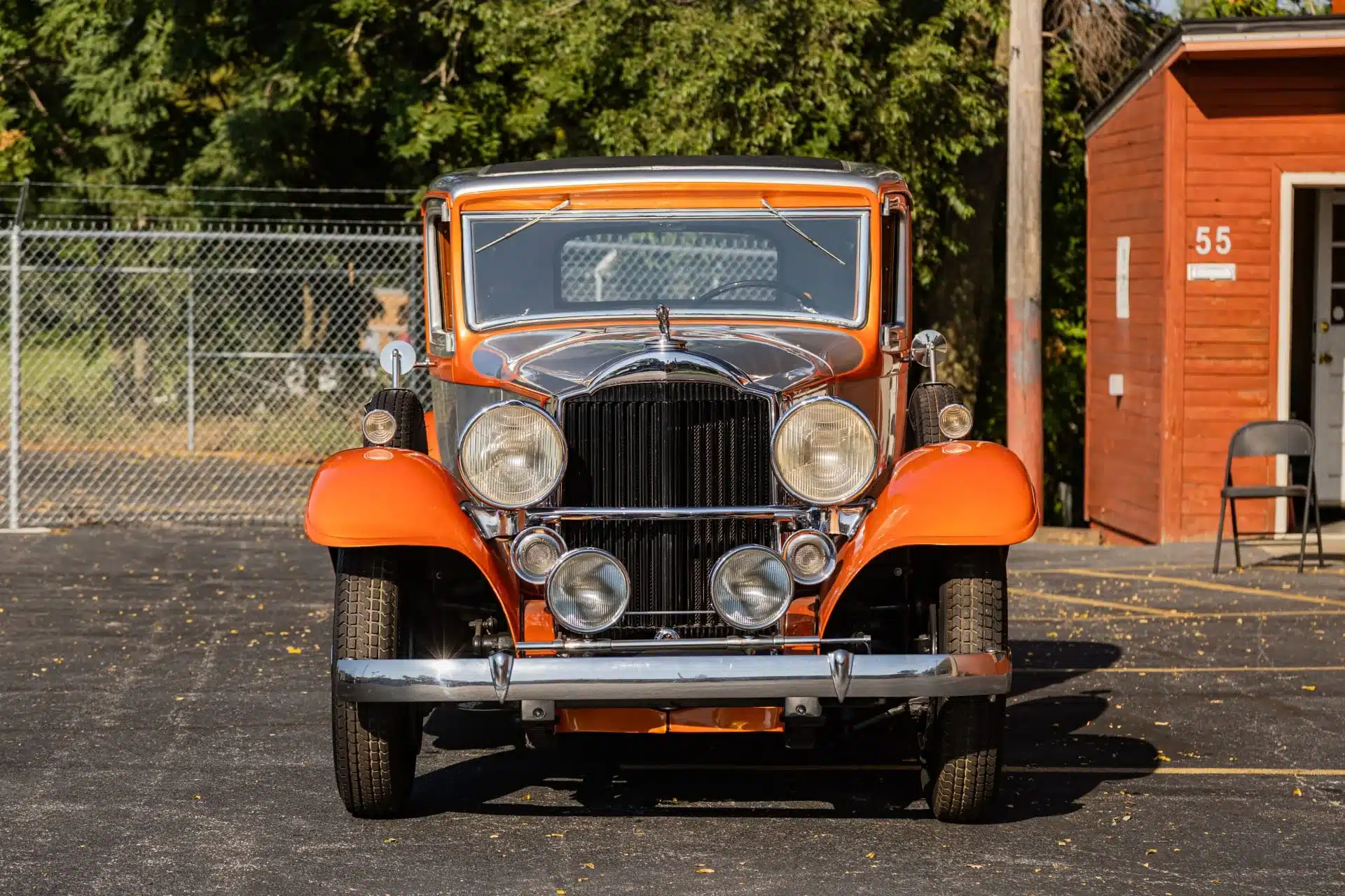 Vorderansicht eines orangefarbenen Packard Model 902 Eight Coupé von 1932 auf einem Parkplatz
