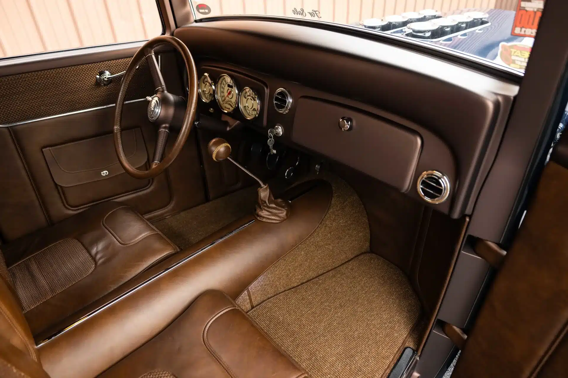 Innenraum mit brauner Lederausstattung, Armaturenbrett und Schalthebel eines Ford Model A Hot Rod Pickup von 1934.