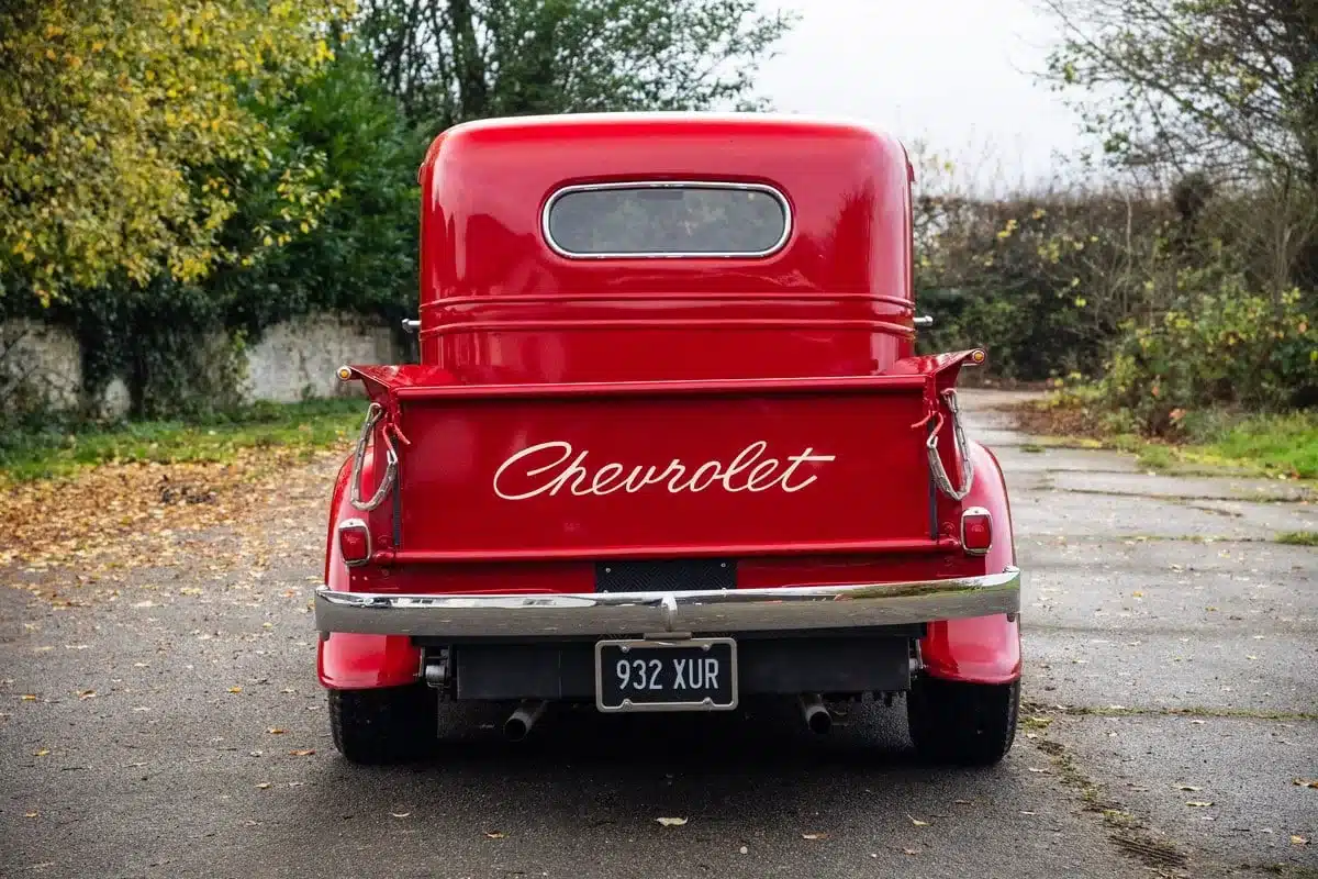 Heckansicht eines roten, restaurierten Chevrolet FB Pickup von 1936 mit geöffnetem Ladebord und Schriftzug Chevrolet