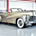 Cadillac Series 62 Cabriolet von 1947 in metallic Champagnergold, restauriert, mit offenem Verdeck und weißwandbereiften Rädern.