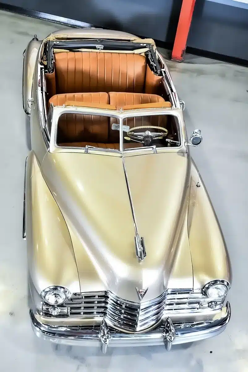 Cadillac Series 62 Cabriolet von 1947 mit beigem Lederinterieur und Champagnergold-Lackierung aus der Vogelperspektive.