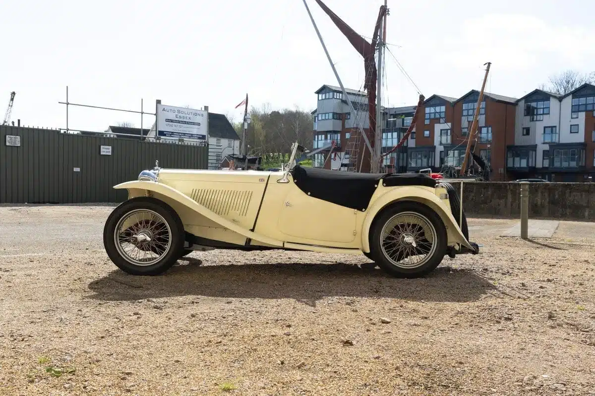 Seitliche Ansicht eines restaurierten MG TC Midget von 1948 in beige mit schwarzem Verdeck