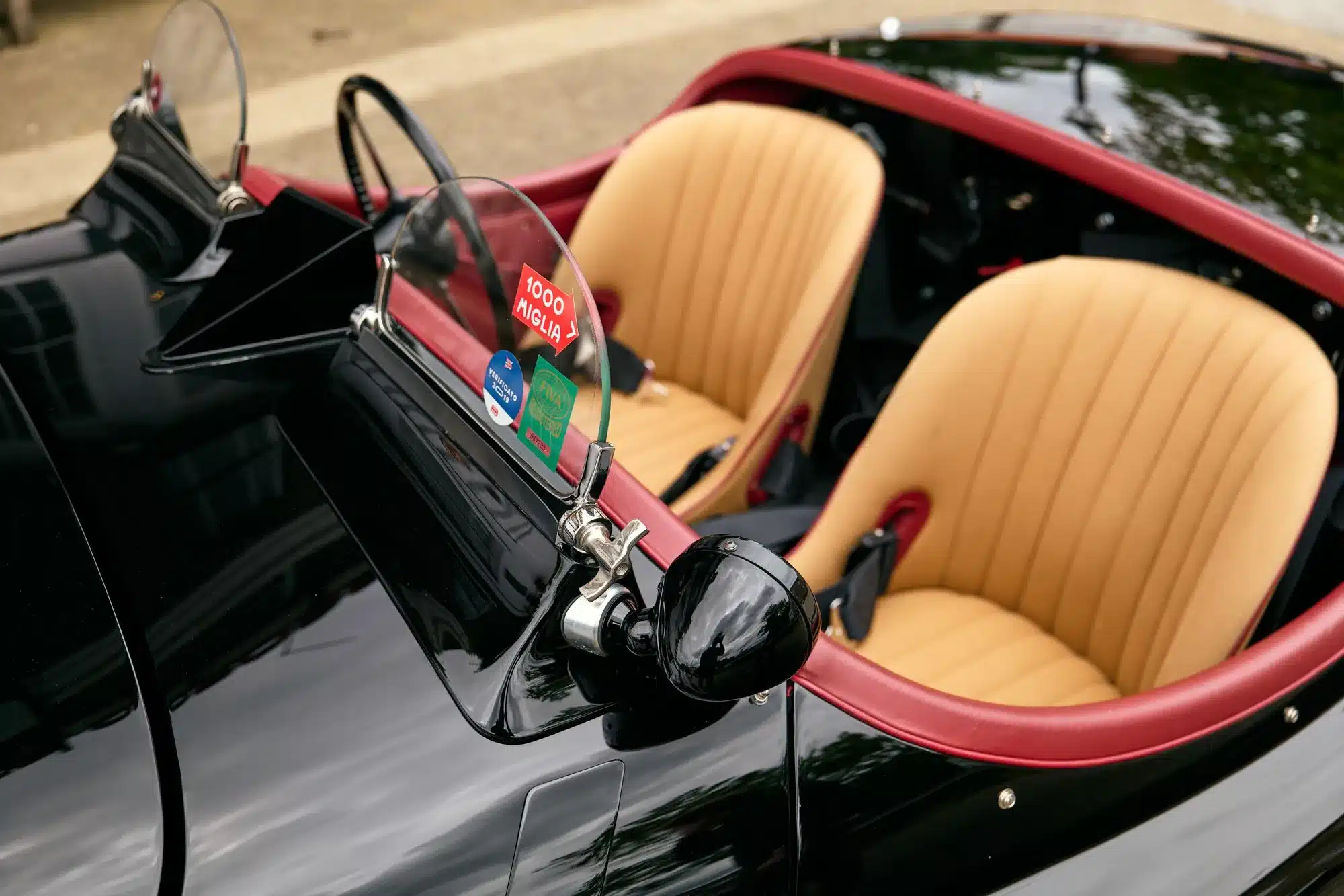 Cockpit und Sportsitze des restaurierten Jaguar XK120 Competition Roadster von 1951 mit Rennwindschutzscheiben, Biscuit-Leder und rotem Interieur.