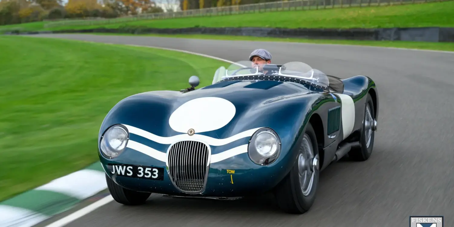 Jaguar C-Type XKC 006 in Dunkelgrün mit weißer Startnummer auf Rennstrecke, Frontansicht, Fahrer mit Schiebermütze