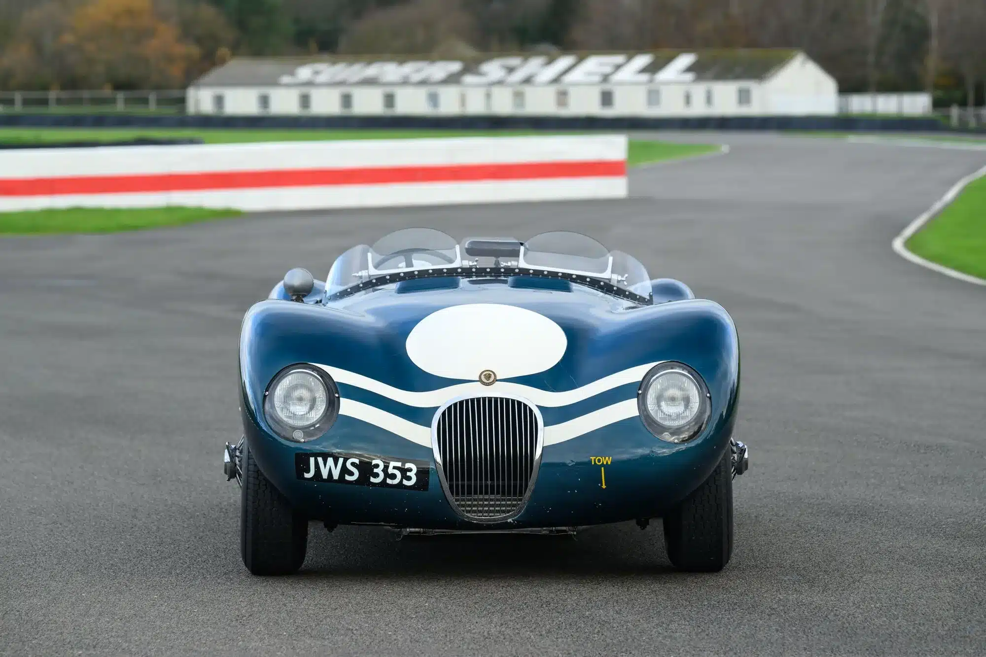 1952er Jaguar C-Type XKC 006 in blauer Lackierung mit Startnummer JWS 353 auf einer Rennstrecke, frontal fotografiert.