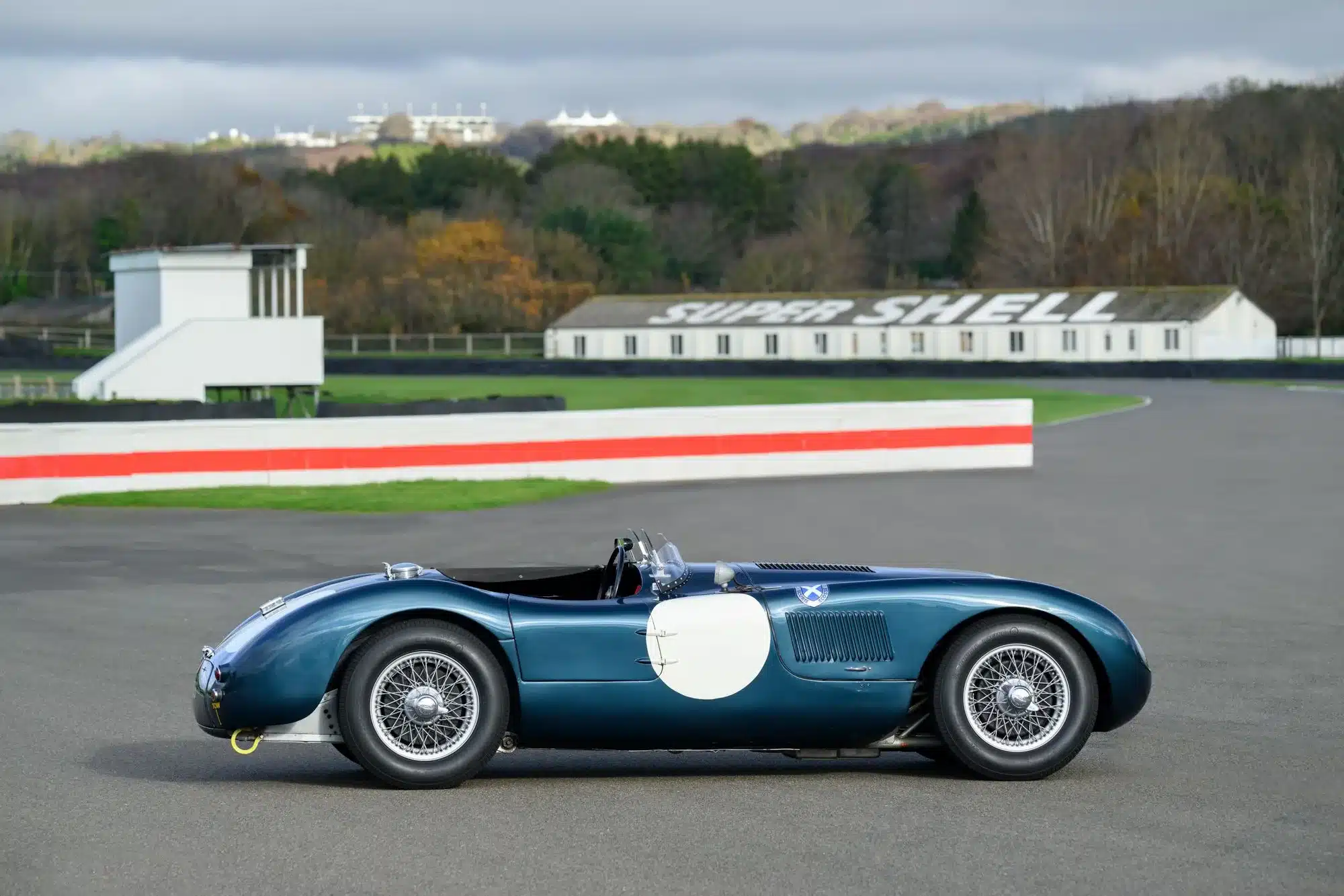 Historischer Jaguar C‑Type XKC 006 von 1952 in blauer Lackierung auf einer Rennstrecke, Seitenansicht