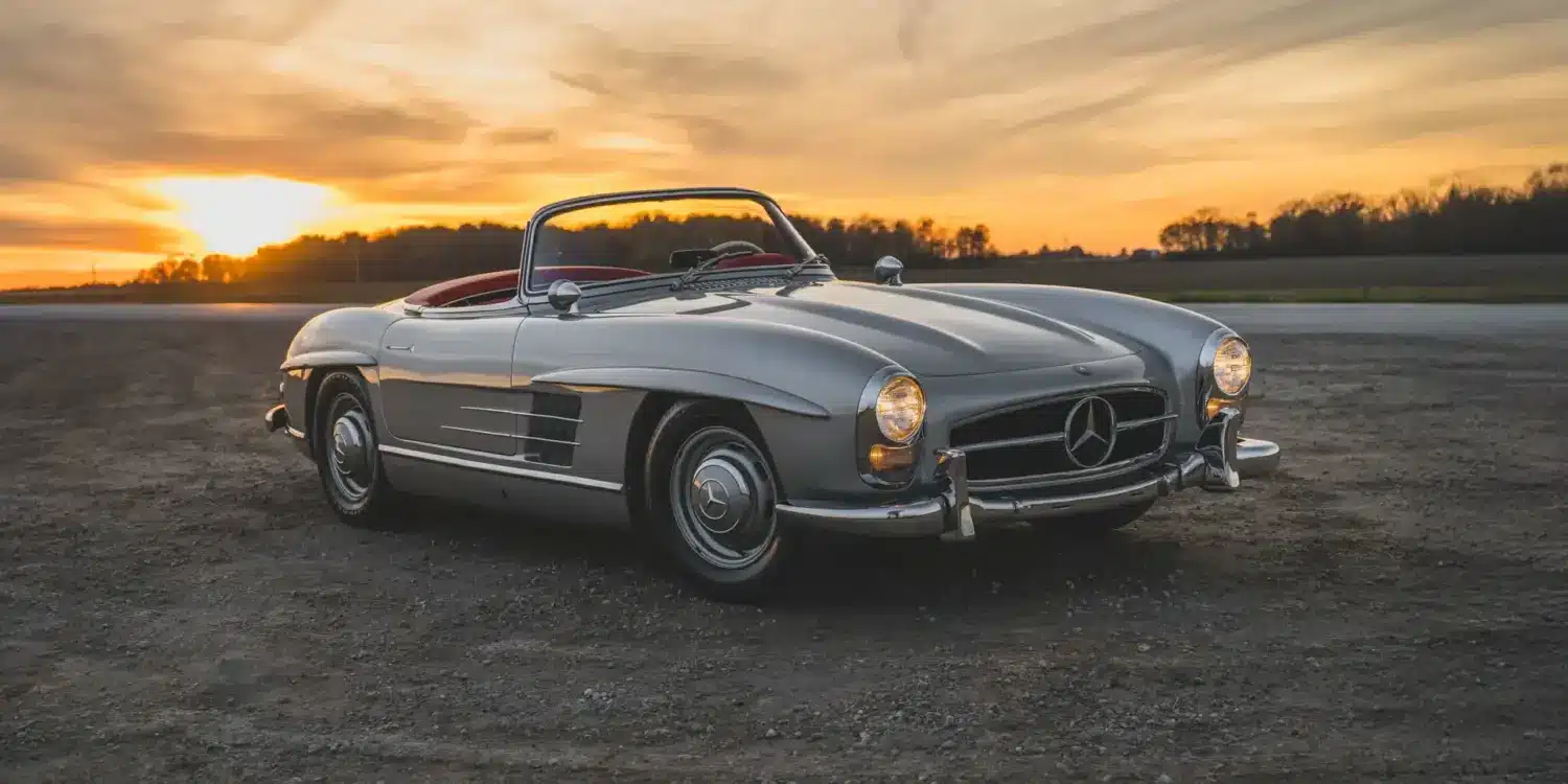 1957 Mercedes-Benz 300 SL Roadster in Silber mit rotem Lederinterieur und offenem Verdeck bei Sonnenuntergang