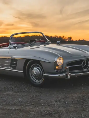 1957 Mercedes-Benz 300 SL Roadster in Silber mit rotem Lederinterieur und offenem Verdeck bei Sonnenuntergang