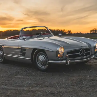 1957 Mercedes-Benz 300 SL Roadster in Silber mit rotem Lederinterieur und offenem Verdeck bei Sonnenuntergang