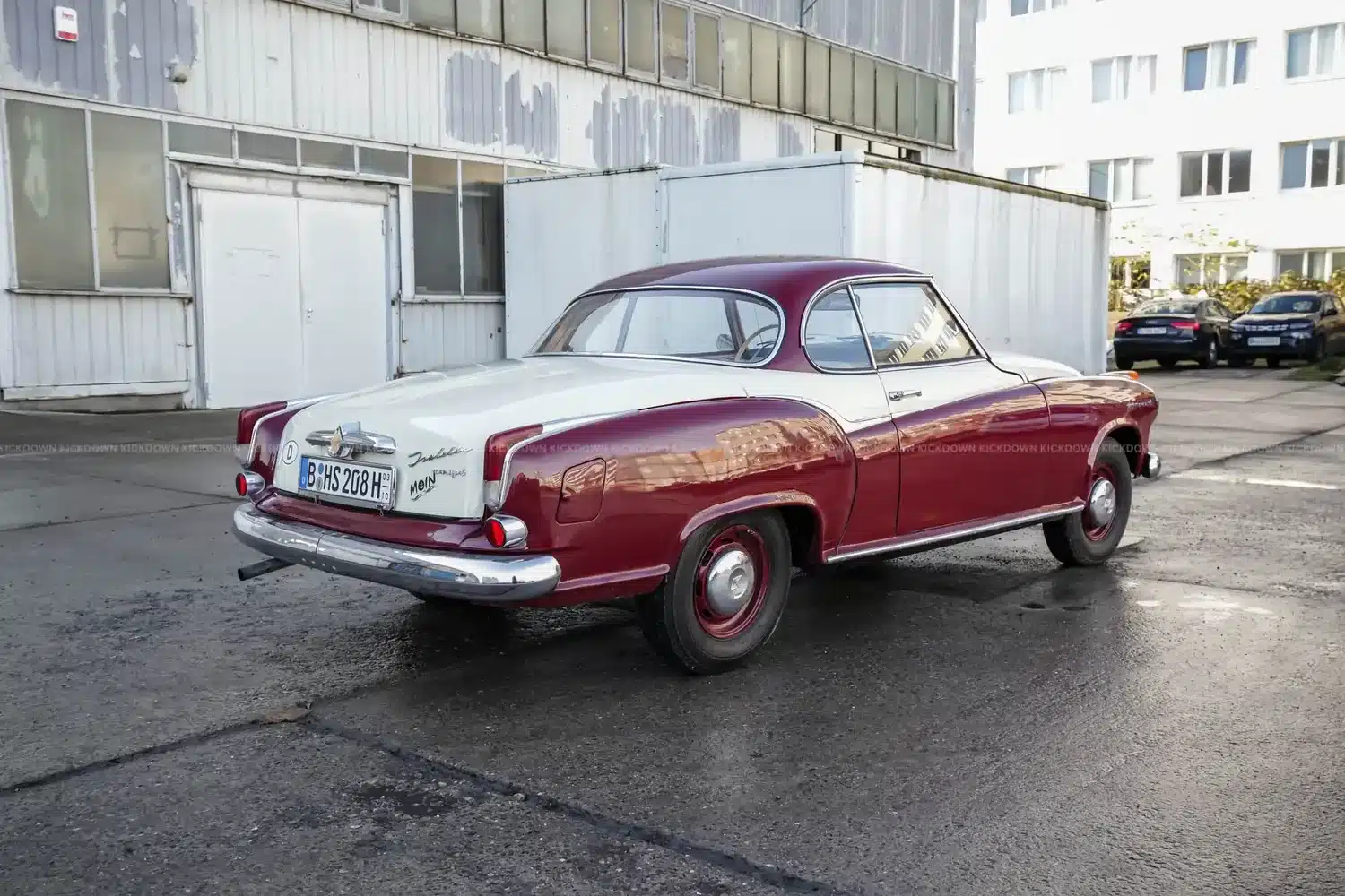 Heckansicht eines zweifarbig lackierten Borgward Isabella Coupé aus dem Jahr 1961, geparkt auf einem Industriegelände.