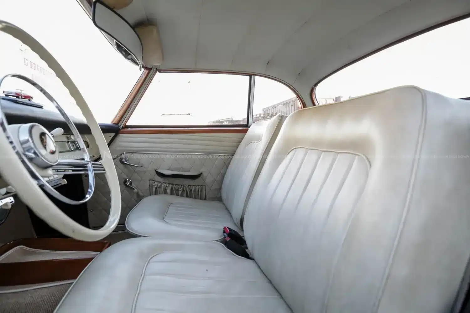 Innenansicht eines Borgward Isabella Coupé von 1961 mit cremefarbenen Polstern und Lenkrad.