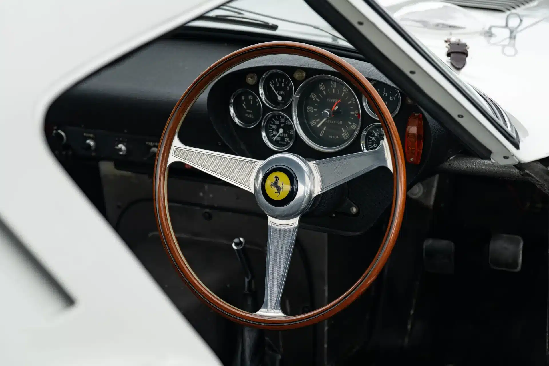 Innenaufnahme des Cockpits eines Ferrari 250 GTO von 1962 mit originalem Holzlenkrad und Instrumentenbrett.