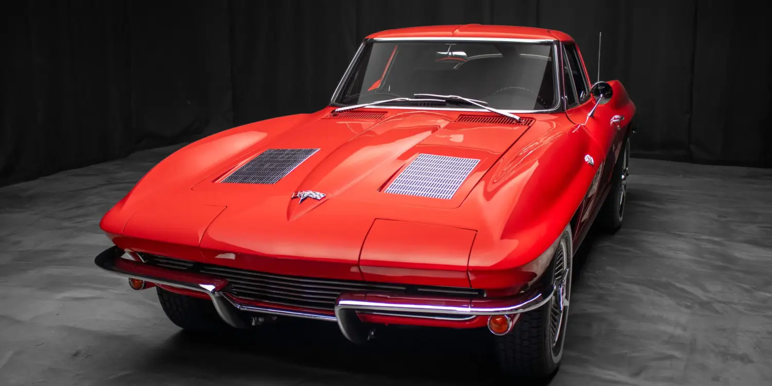 Rote 1963 Chevrolet Corvette Split-Window, frontal vor dunklem Hintergrund.