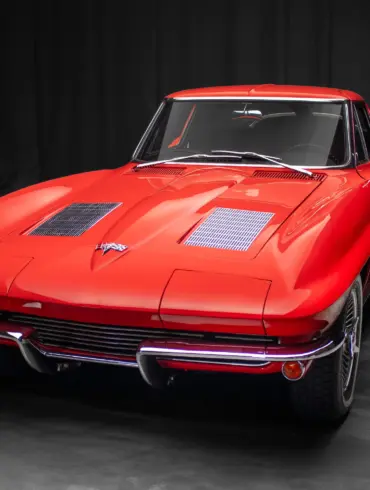 Rote 1963 Chevrolet Corvette Split-Window, frontal vor dunklem Hintergrund.