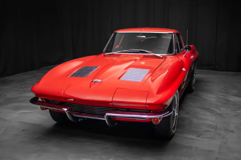 Rote 1963 Chevrolet Corvette Split-Window, frontal vor dunklem Hintergrund.