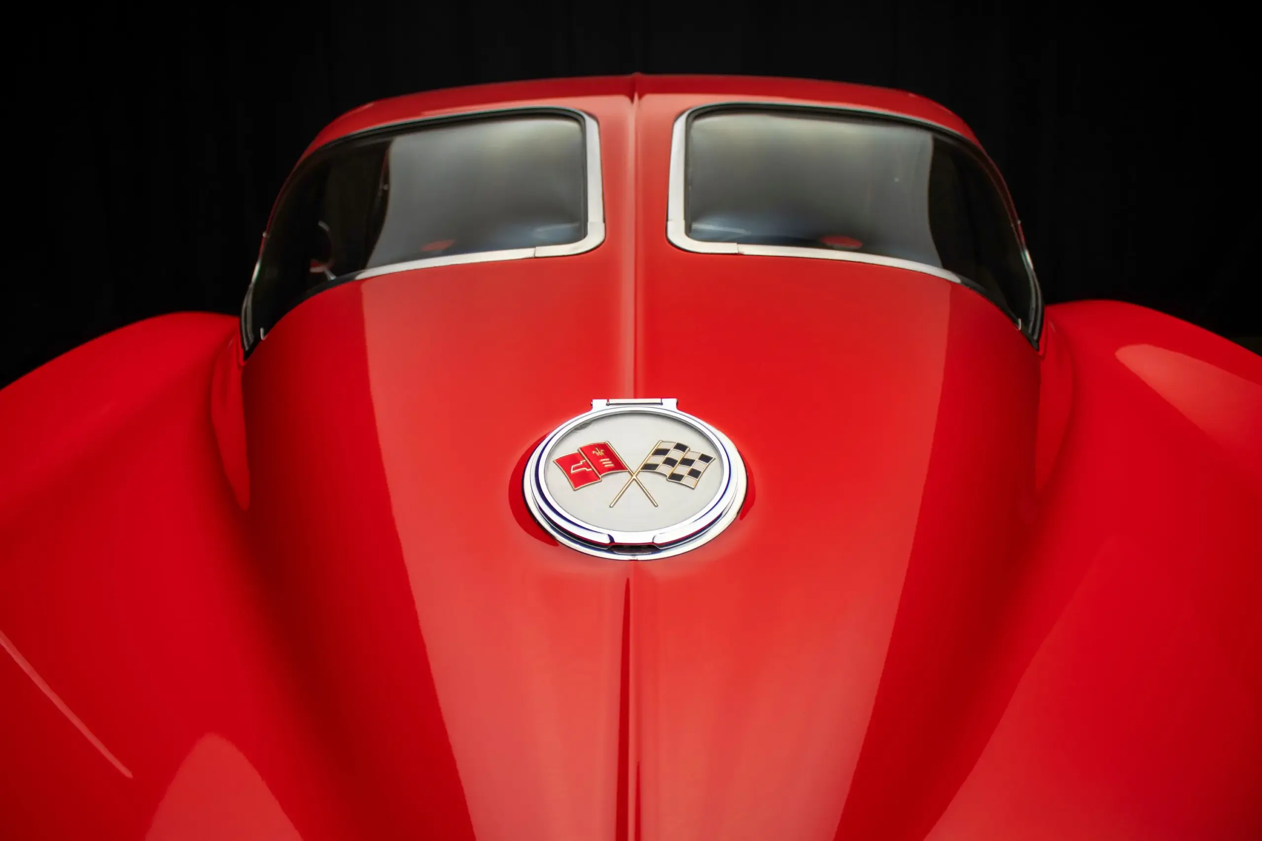 Heckansicht einer roten 1963 Chevrolet Corvette Split-Window mit geteiltem Rückfenster und Corvette-Emblem.