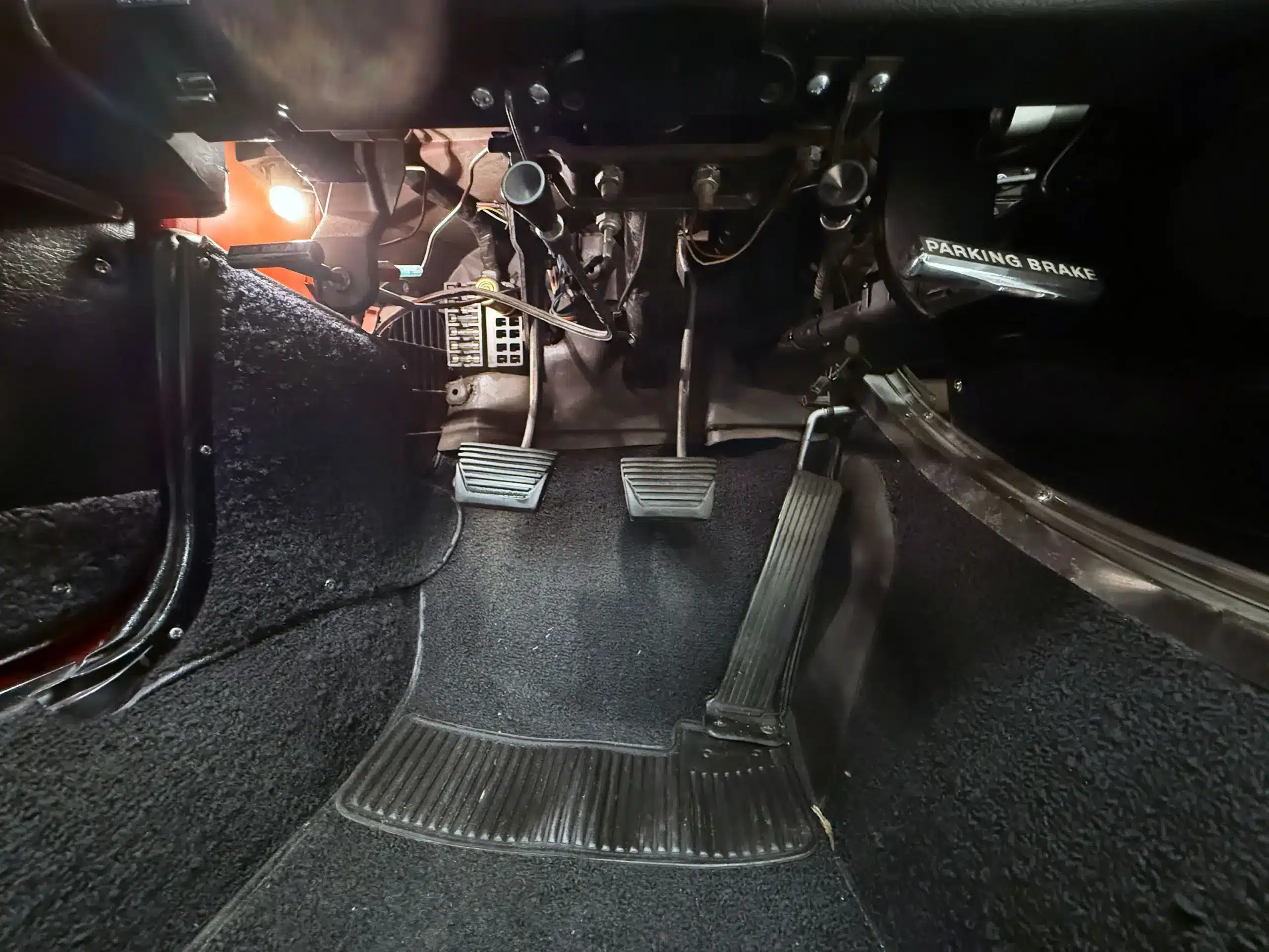 Pedalerie, Gummi-Matten und Handbremse im Fußraum einer restaurierten 1963 Chevrolet Corvette Split-Window.