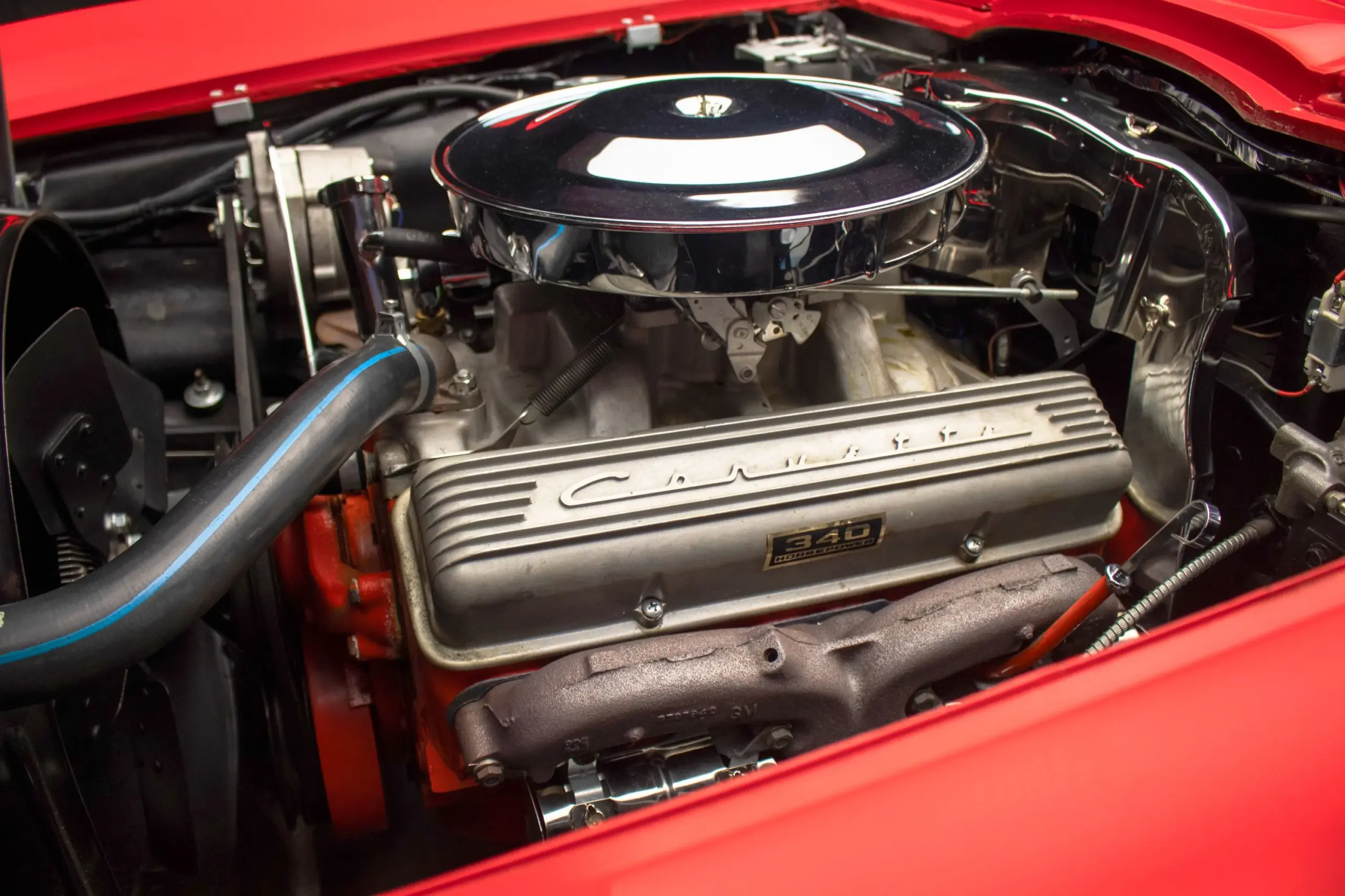 Nahaufnahme des V8-Motors einer 1963 Chevrolet Corvette Split-Window mit sichtbarem Corvette-Schriftzug und 340 PS Plakette.