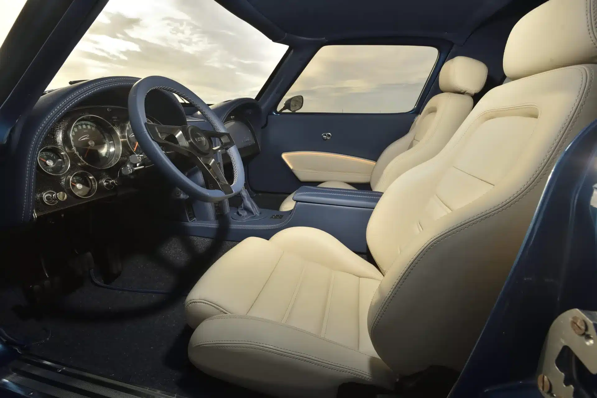 Innenansicht einer 1963 Chevrolet Corvette Split Window mit cremefarbenen Ledersitzen und klassischem Armaturenbrett.