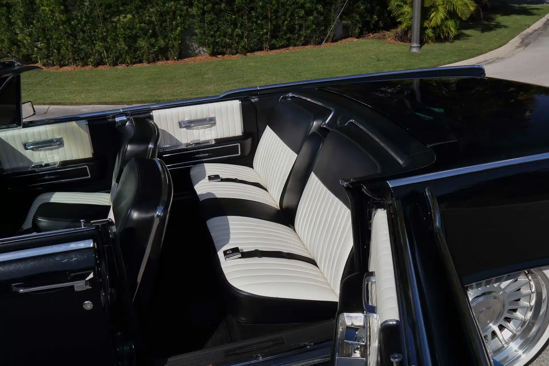 Innenansicht eines 1964 Lincoln Continental Cabriolets mit geöffneten hinten angeschlagenen Türen und schwarz-weißer Lederausstattung.