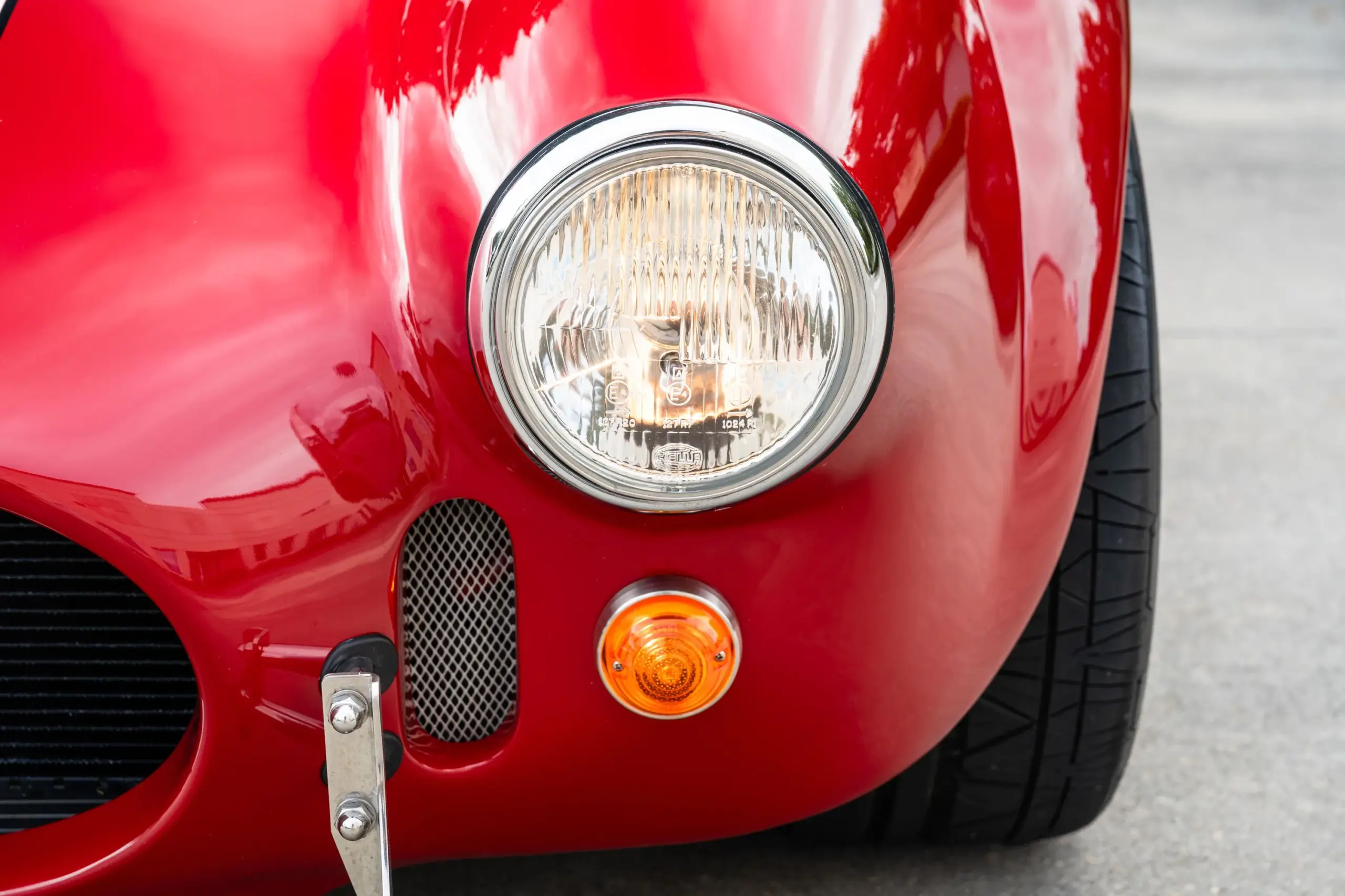 Frontscheinwerfer und Blinker einer roten 1965 Ford Backdraft Cobra mit Chromdetails