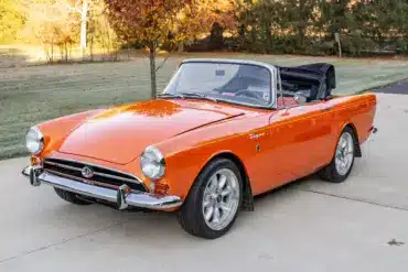 Sunbeam Tiger Mk1 Roadster in warmer Creamsicle-Perleffektlackierung, offen, auf einer Auffahrt.