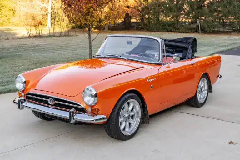 Sunbeam Tiger Mk1 Roadster in warmer Creamsicle-Perleffektlackierung, offen, auf einer Auffahrt.