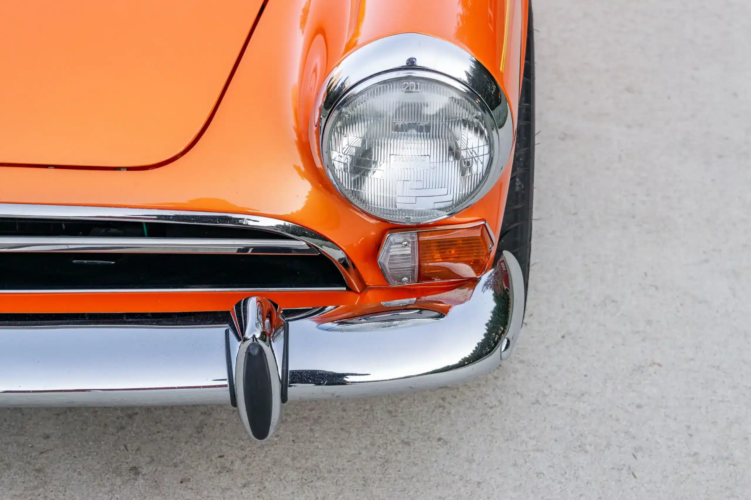 Frontansicht eines Sunbeam Tiger Mk1 mit orangefarbener Lackierung und verchromtem Stoßfänger.
