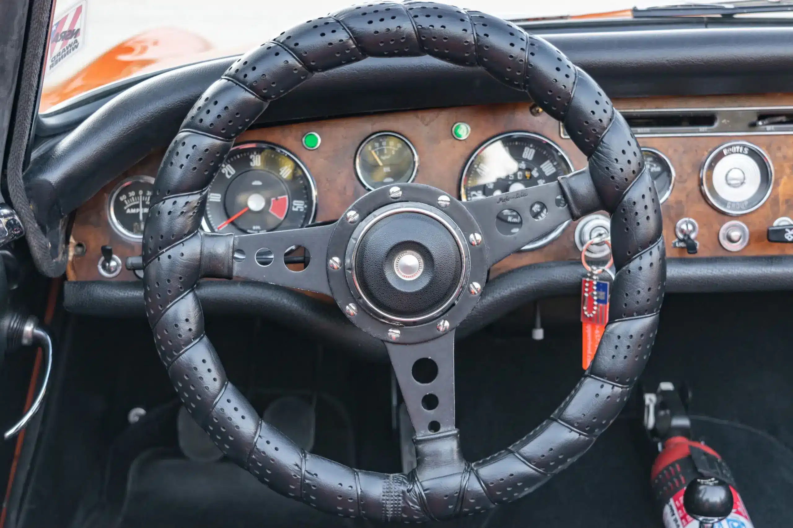 Detailaufnahme des originalen Lenkrads und Armaturenbretts eines Sunbeam Tiger Mk1 mit Jaeger-Instrumenten und Holzapplikation.