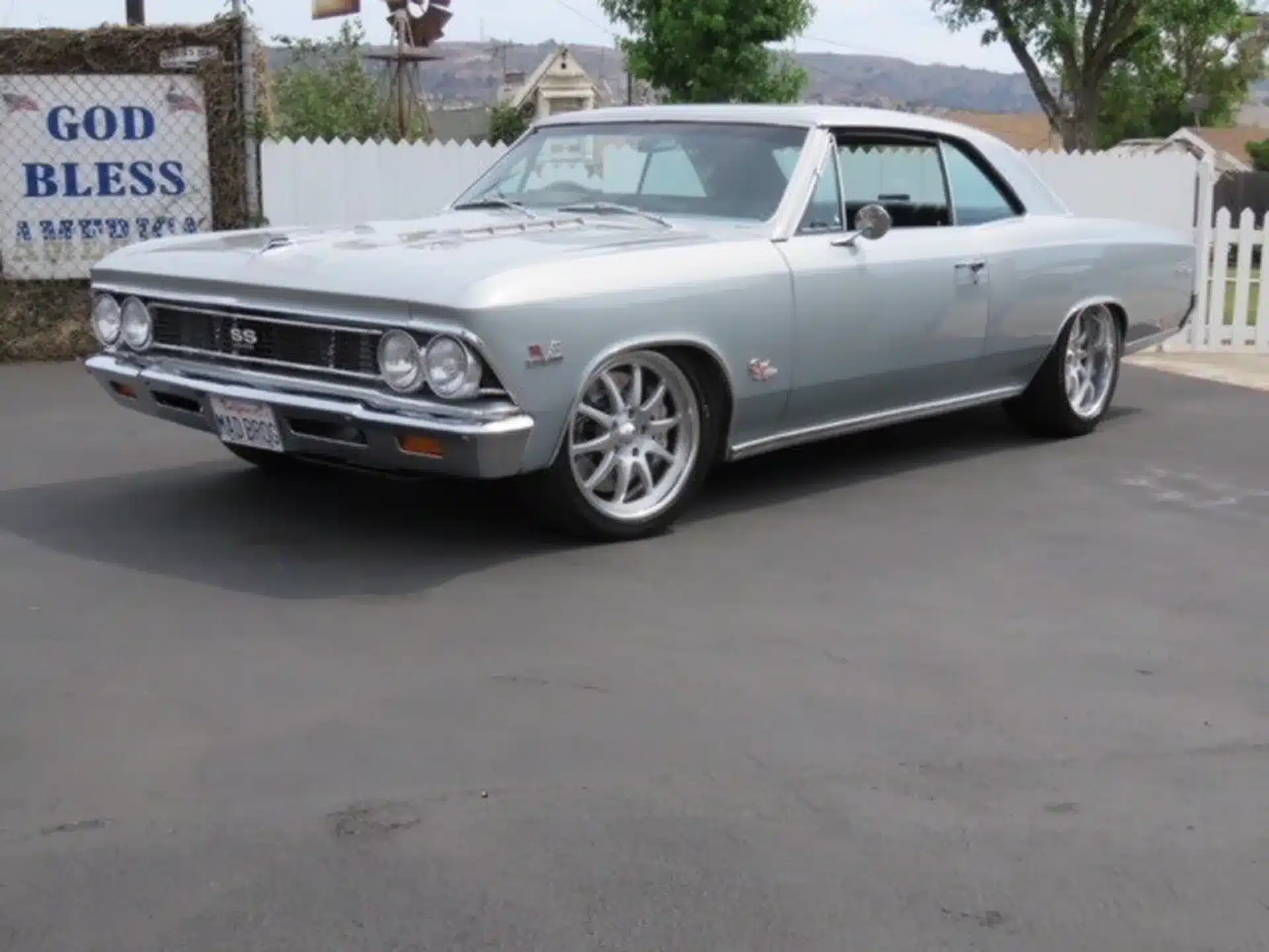 1966 Chevrolet Chevelle SS Coupé, silber, Seitenansicht vor weißem Zaun, moderne Felgen.