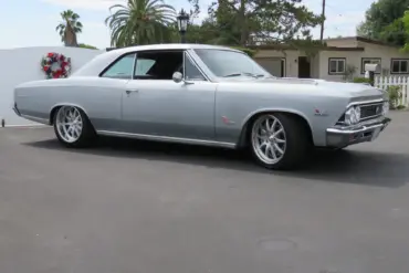 1966 Chevrolet Chevelle SS 396 silberfarben, seitlich aufgenommen vor Wohnhaus und Palmen.