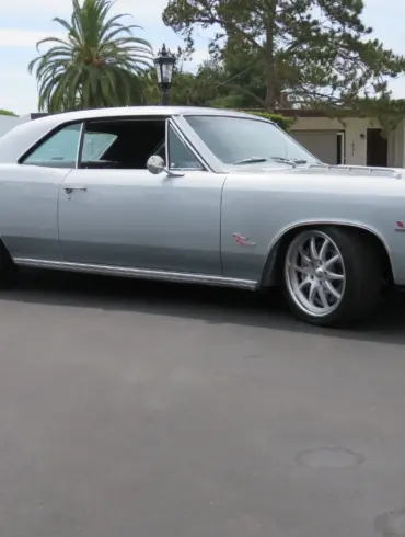 1966 Chevrolet Chevelle SS 396 silberfarben, seitlich aufgenommen vor Wohnhaus und Palmen.