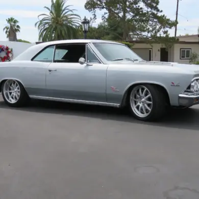 1966 Chevrolet Chevelle SS 396 silberfarben, seitlich aufgenommen vor Wohnhaus und Palmen.