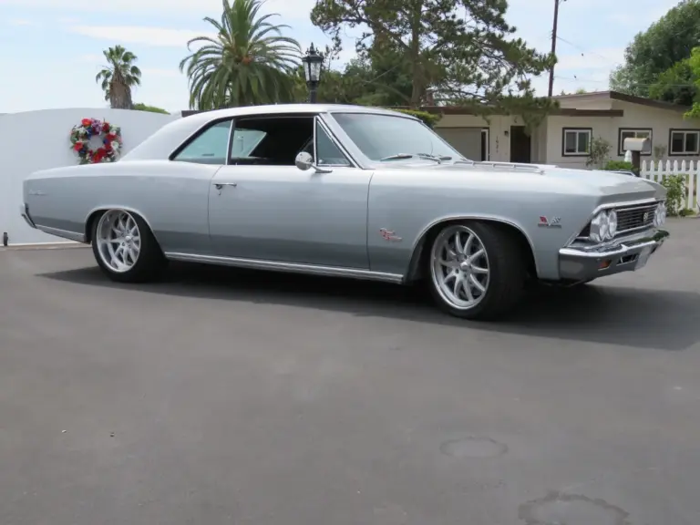 1966 Chevrolet Chevelle SS 396 silberfarben, seitlich aufgenommen vor Wohnhaus und Palmen.