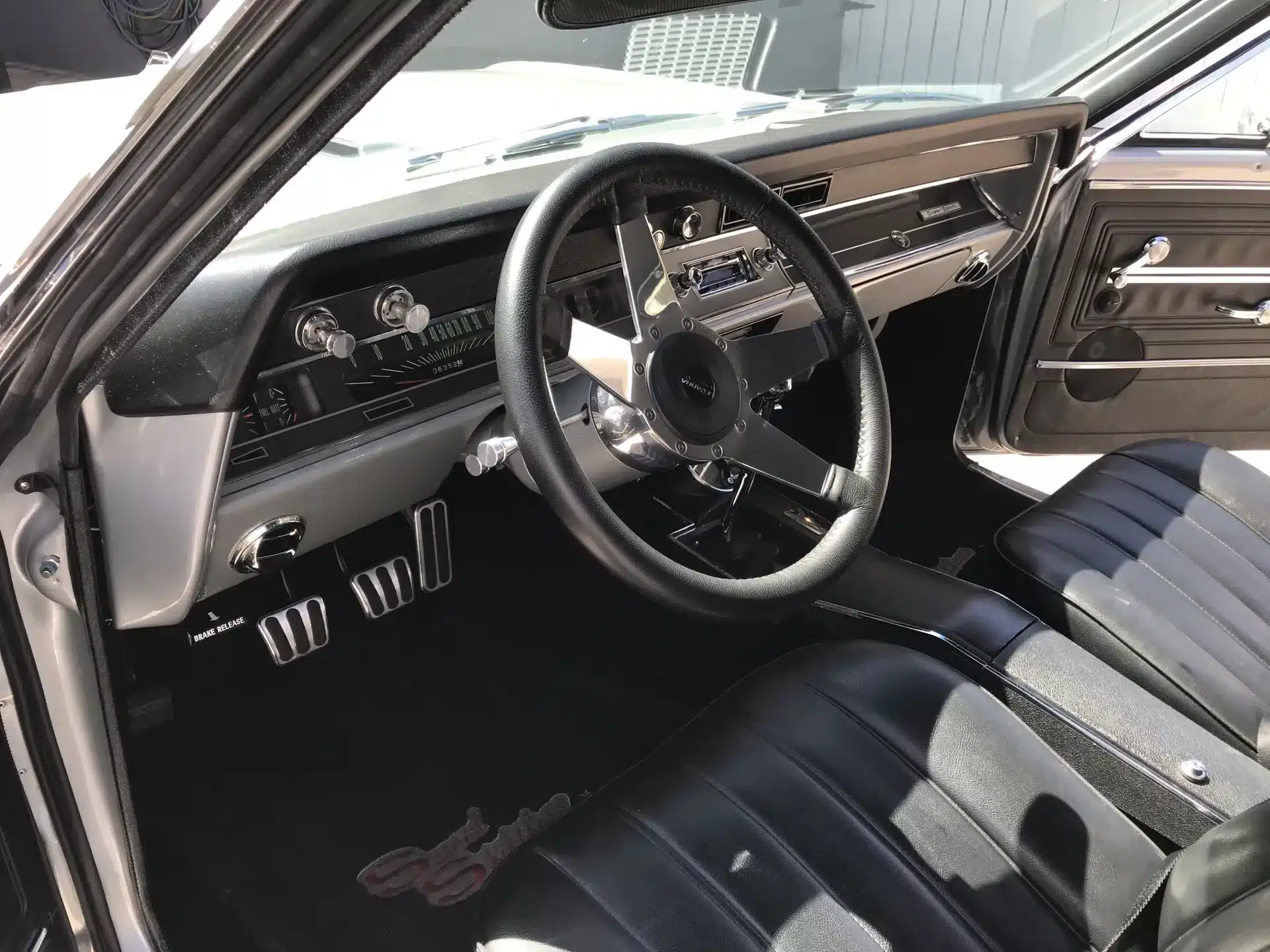 Innenansicht einer 1966 Chevrolet Chevelle mit schwarzer Lederausstattung und klassischen Bedienelementen