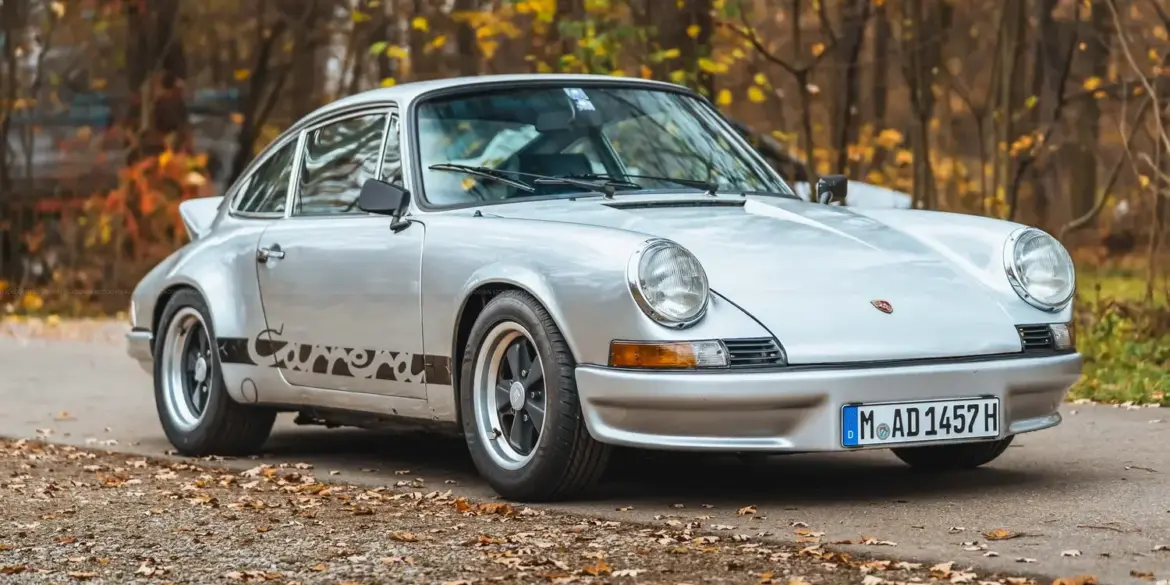 Silberner Porsche 911 S SWB Baujahr 1967 mit originalen Fuchs-Felgen und RS-inspirierten Karosserieelementen auf einer herbstlichen Straße.