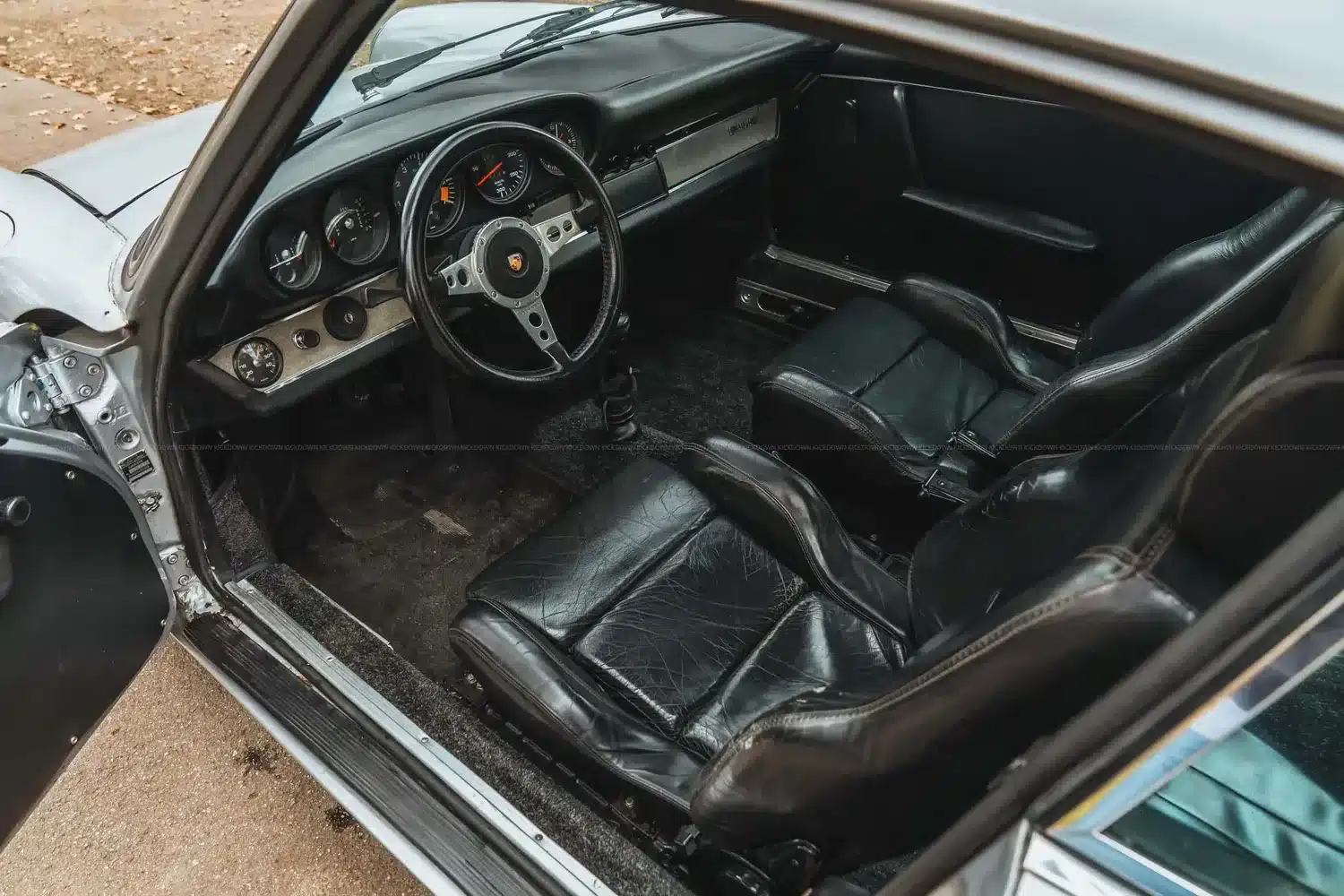 Blick in den Innenraum eines Porsche 911 S SWB von 1967 mit schwarzen Ledersitzen und klassischen Armaturen.