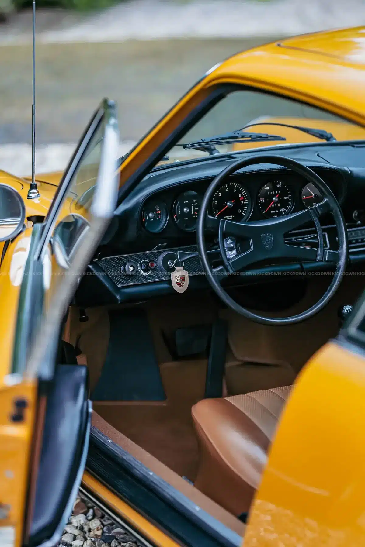 Blick in den Innenraum eines gelben Porsche 911 T Sportomatic von 1969 mit Fokus auf Lenkrad und Armaturenbrett