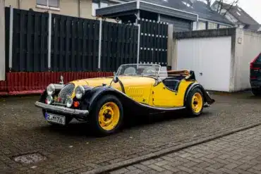 Morgan 4/4 Competition Baujahr 1971 in schwarz-gelber Farbkombination, Cabriolet, frontal seitlich abgelichtet.