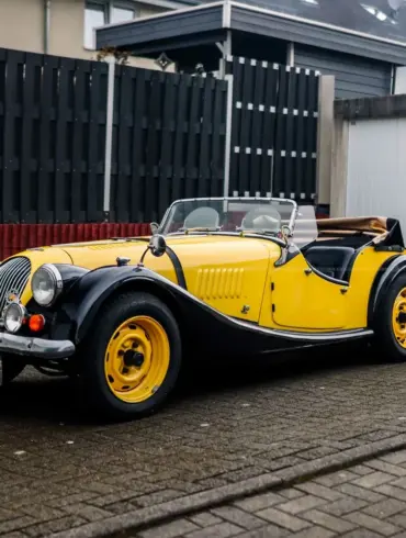 Morgan 4/4 Competition Baujahr 1971 in schwarz-gelber Farbkombination, Cabriolet, frontal seitlich abgelichtet.