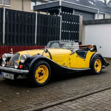 Morgan 4/4 Competition Baujahr 1971 in schwarz-gelber Farbkombination, Cabriolet, frontal seitlich abgelichtet.