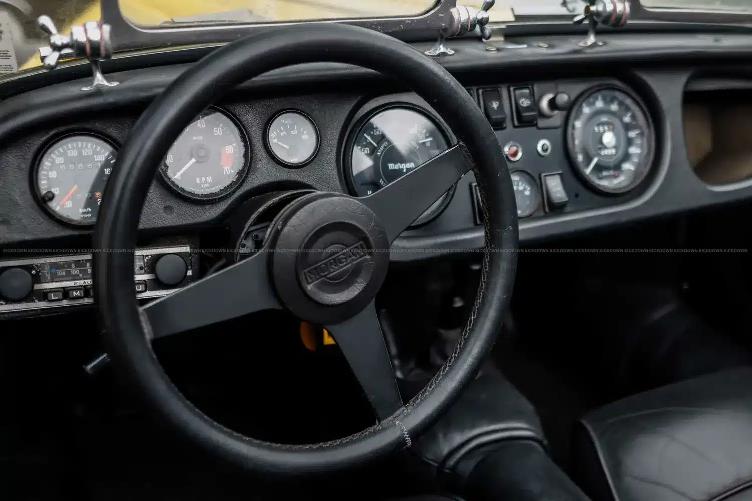 Innenraum und Armaturenbrett eines Morgan 4/4 Competition von 1971, mit Lenkrad und klassischen Instrumenten.