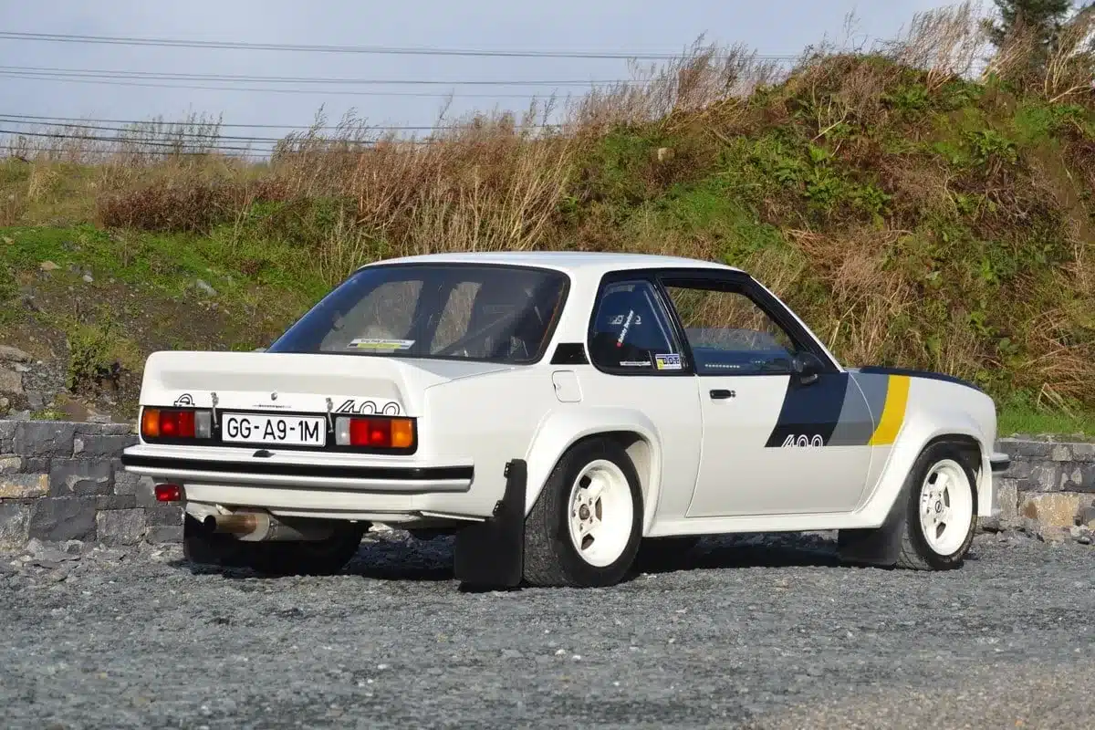 Restaurierter Opel Ascona 400R, Baujahr 1980, von schräg hinten fotografiert, mit Rallye-Ausstattung und auffälligen weißen Felgen.