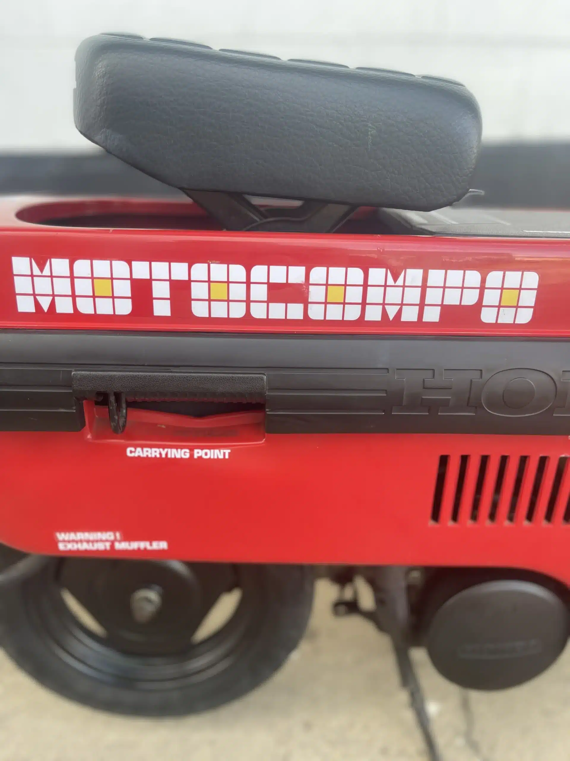 Roter Honda Motocompo Scooter, Detailaufnahme mit Sitz, Schriftzug und Tragegriff