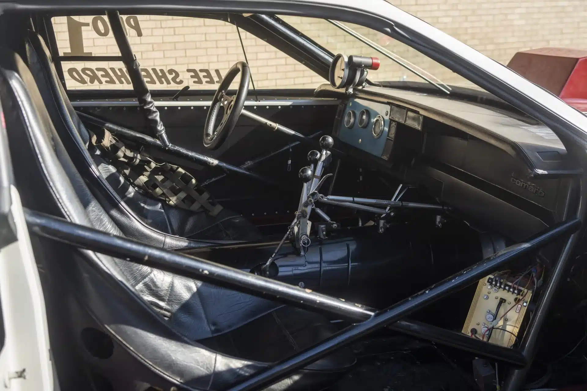 Rennwagen-Innenraum eines 1984 Chevrolet Camaro mit Überrollkäfig, Schalthebeln und Spezialinstrumenten